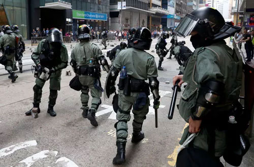 Cảnh sát thu gom gạch do người biểu tình đặt trên đường để cản trở giao thông ở Hồng Kông hôm 14-11