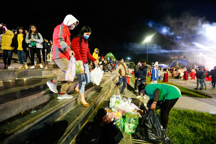 Nhiều bạn trẻ giúp nhân viên vệ sinh môi trường dọn dẹp rác khi trận đấu kết thúc 