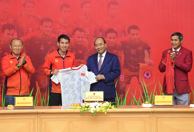 Đại diện U22 Việt Nam trao tặng Thủ tướng Nguyễn Xuân Phúc chiếc áo với chữ ký của các thành viên đội tuyển.