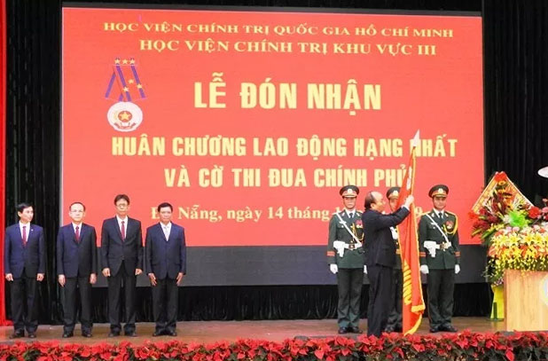 Thủ tướng Nguyễn Xuân Phúc gắn Huân chương Lao động hạng Nhất lên lá cờ truyền thống của Học viện Chính trị khu vực III