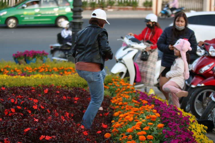 Một số người thiếu ý thức, ngang nhiên dẫm lên khuôn viên hoa để chụp hình tại công viên Trần Hưng Đạo