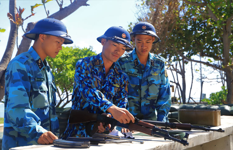 Đại úy Cù Văn Thuần (chính giữa) hướng dẫn chiến sĩ cách bảo dưỡng súng sẵn sàng chiến đấu bảo vệ chủ quyền biển đảo thiêng liêng của Tổ quốc. Ảnh: K.P
