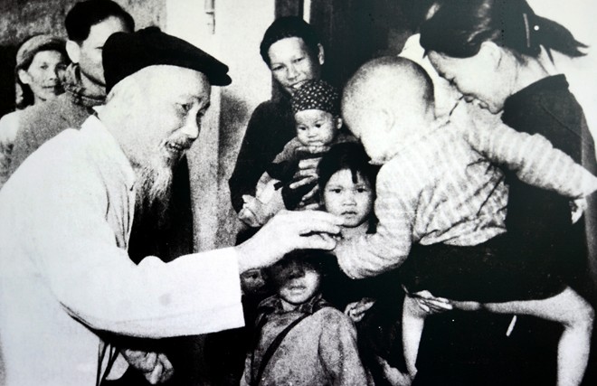 Bác Hồ chia quà Tết cho các cháu nhỏ ở hợp tác xã Khe Cát, huyện Yên Hưng, tỉnh Quảng Ninh, ngày 2/2/1965. Ảnh: Tư liệu
