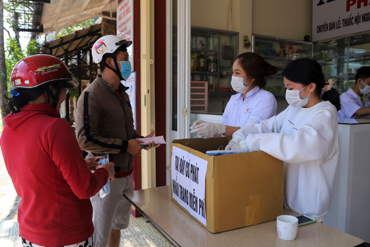 Nhân viên nhà thuốc phát khẩu trang y tế miễn phí cho người dân