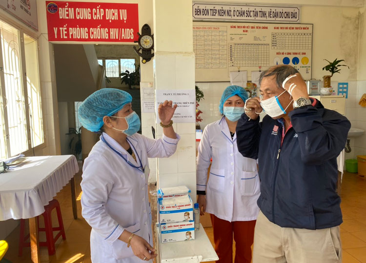 Trạm Y tế Phường 3, TP Đà Lạt phát miễn phí và hướng dẫn người dân đeo khẩu trang y tế đúng cách để phòng dịch. Ảnh: T.Trang