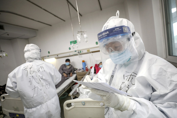 Một nhân viên y tế mặc đồ bảo hộ đang kiểm tra bệnh án của người bệnh tại bệnh viện Kim Ngân Đàm ở Vũ Hán, tỉnh Hồ Bắc, Trung Quốc ngày 13-2-2020
