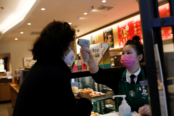 Nhân viên tiệm cà phê Starbuck ở Bắc Kinh kiểm tra nhiệt độ của khách mua hàng