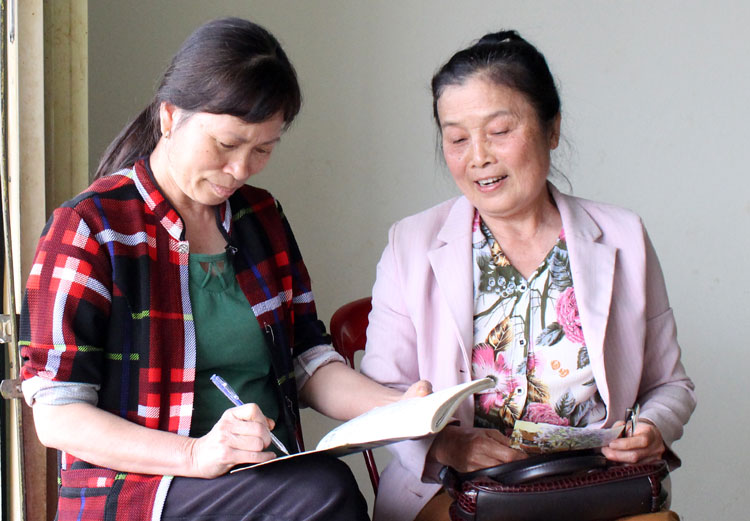 Bà Phạm Thị Quyết (bên phải), Tổ trưởng Tổ tiết kiệm trao số tiền tiết kiệm hàng tháng cho hội viên.