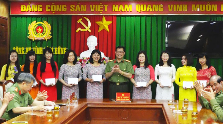 Đồng chí Giám đốc Công an tỉnh Lê Vinh Quy trao biểu trưng là 500 chiếc áo dài cho đại diện phụ nữ công an tỉnh