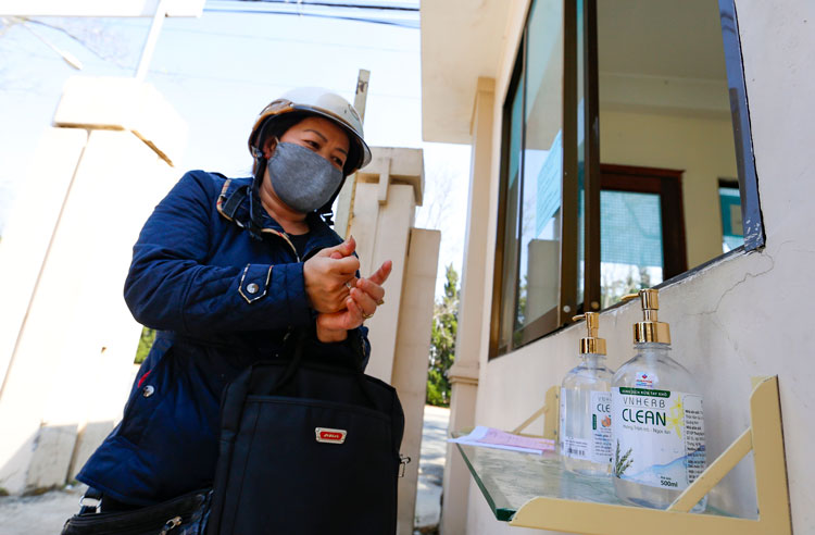 Người dân tới Đội CSGT Công an Đà Lạt làm hồ sơ rửa tay bằng nước sát khuẩn trước khi vào trụ sở cơ quan