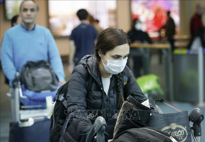 Hành khách đeo khẩu trang phòng lây nhiễm COVID-19 tại sân bay quốc tế Vancouver ở Richmond, Canada ngày 16/3