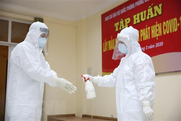 Nhân viên y yế khử khuẩn sau khi lấy mẫu bệnh phẩm của người nghi nhiễm SARS-CoV-2.