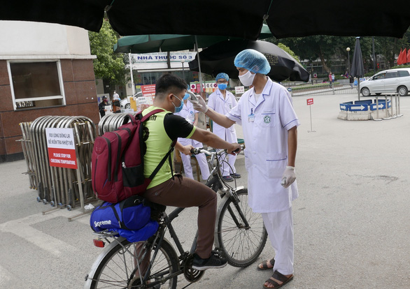 Đo nhiệt độ khách vào Bệnh viện Bạch Mai, cơ sở đã có 3 người bệnh và đang phải dừng nhiều hoạt động, cách ly hơn 400 người vì dịch COVID-19