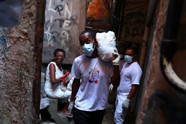 Một tình nguyên viên vận chuyển hàng cứu trợ cho các gia đình nghèo tại khu ổ chuột Rocinha trong lúc bùng phát dịch Covid-19, ở thành phố Rio de Janeiro, Brazil, ngày 27-3-2020