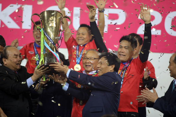 Thủ tướng Nguyễn Xuân Phúc (trái) và HLV Park Hang Seo nâng Cúp vô địch AFF Cup 2018