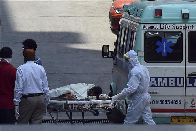 Nhân viên y tế chuyển bệnh nhân nghi mắc COVID-19 từ xe cứu thương vào một bệnh viện ở New Delhi, Ấn Độ ngày 27/4