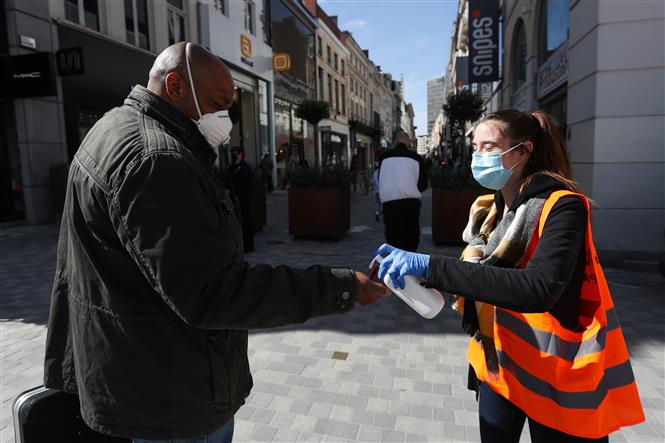 Xịt nước sát khuẩn tay cho người dân tại Brussels, Bỉ ngày 11/5/2020