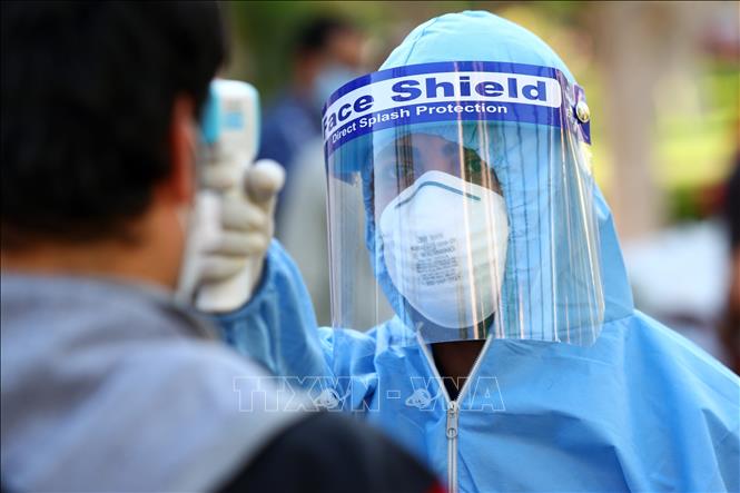 Nhân viên y tế kiểm tra thân nhiệt người dân nhằm ngăn chặn sự lây lan của dịch COVID-19 tại Giza, Ai Cập ngày 10/5. 