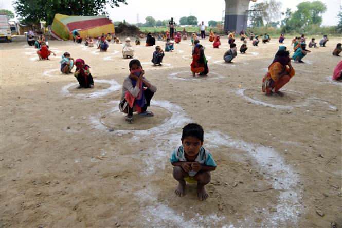 Trẻ em thực hiện giãn cách xã hội phòng lây nhiễm COVID-19 khi xếp hàng chờ nhận bữa ăn miễn phí tại East Delhi, Ấn Độ ngày 11/5/2020