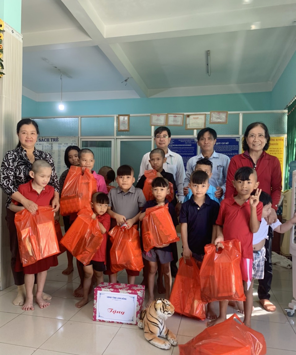 Bà Lê Thị Thêu (ngoài cùng bên trái) trao quà và chụp hình lưu niệm cùng các em tại Cơ sở bảo trợ madagui (thị trấn Madagui, huyện Đạ Huoai)