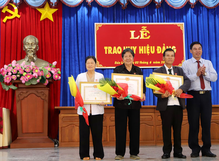 Đồng chí Nghiêm Xuân Đức - Phó Bí thư Thành ủy Bảo Lộc trao Huy hiệu 50 năm tuổi Đảng cho các đảng viên