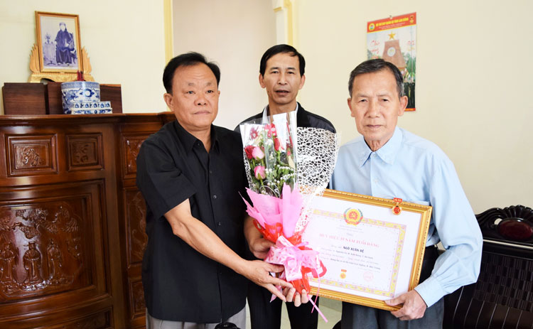 Đồng chí Lê Hồng Khánh – Phó Bí thư Thường trực Huyện ủy Đức Trọng, trao Huy hiệu 55 năm tuổi Đảng cho Anh hùng Lực lượng vũ trang Ngô Xuân Đệ
