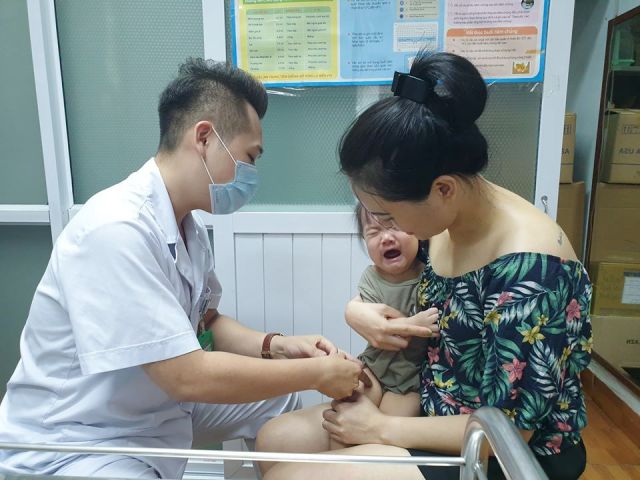 Nhân viên y tế tiêm vắc xin cho trẻ tại Phòng tiêm chủng vắc xin, BV Bệnh Nhiệt đới Trung ương