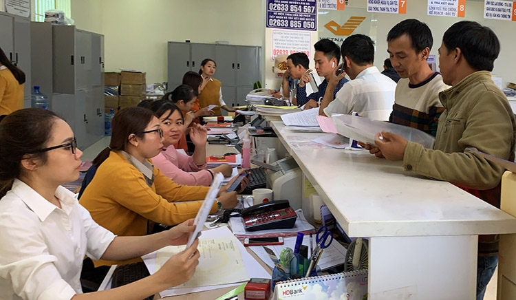 Nhân viên Bưu điện đang tiếp nhận hồ sơ giải quyết TTHC của người dân tại Bưu điện Lâm Hà