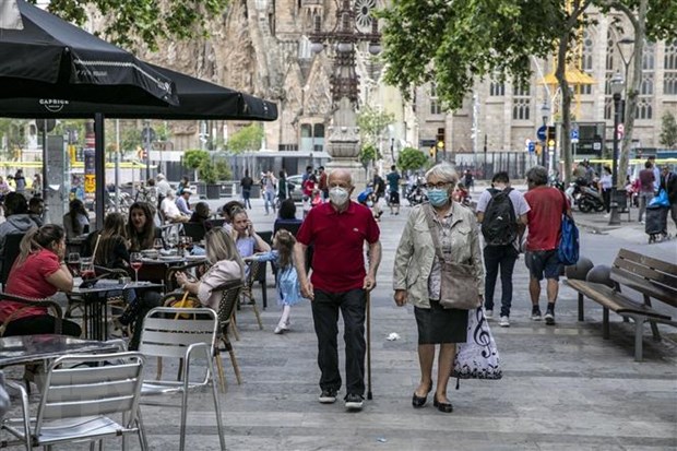 Người dân đeo khẩu trang phòng tránh COVID-19 tại một khu phố ở Barcelona, Tây Ban Nha