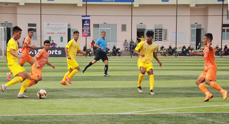 Một pha bóng của các cầu thủ Lâm Đồng (áo vàng) trước Trẻ SHB Đà Nẵng (áo cam)