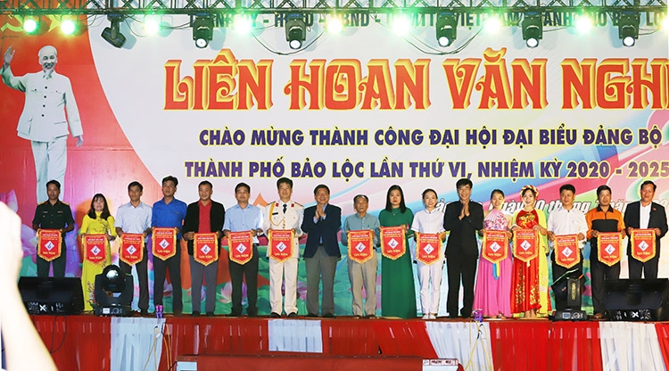 Đồng chí Nguyễn Văn Triệu – Bí thư Thành ủy Bảo Lộc tặng cờ lưu niệm cho các đơn vị tham gia trình diễn tại đêm văn nghệ
