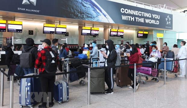 Các công dân Việt Nam xếp hàng chờ làm thủ tục lên máy bay về nước tại sân bay Heathrow