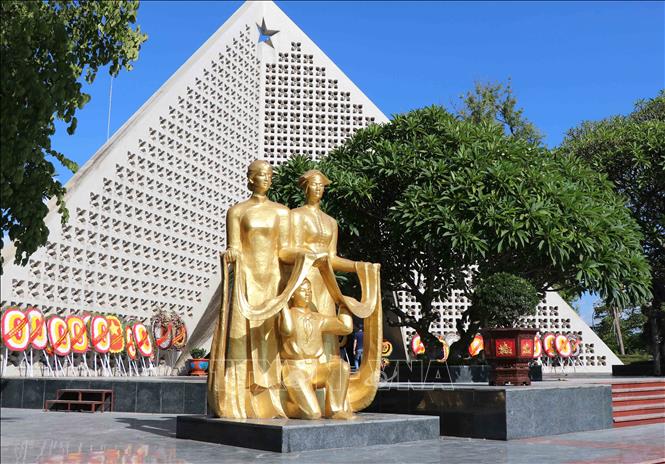 Cụm tượng màu vàng đặt bên trái nghĩa trang là hình tượng hai người phụ nữ dân tộc Thái, Kinh và em bé đang nâng dải lụa