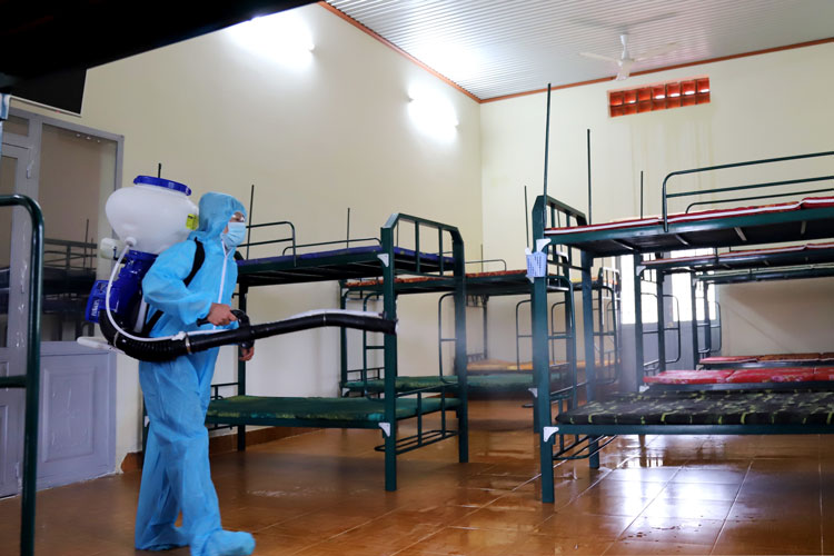 Nhân viên y tế phun xịt khử khuẩn tiếp nhận 2 trường hợp vào cách ly y tế tại Trung tâm huấn luyện tập trung Ban Chỉ huy Quân sự TP Bảo Lộc