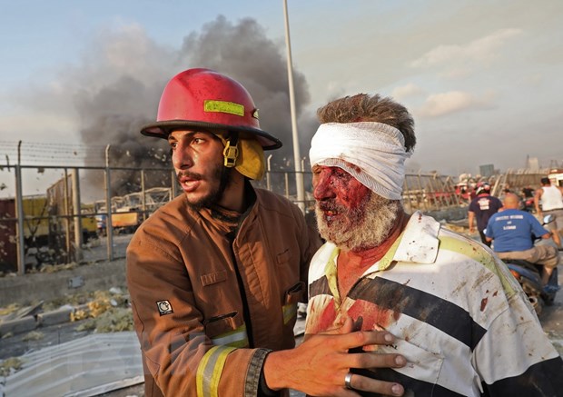 Lính cứu hỏa trợ giúp một nạn nhân bị thương trong vụ nổ kinh hoàng ở Beirut, Liban ngày 4/8/2020