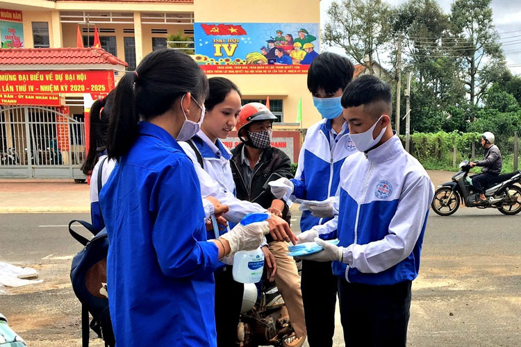 ĐVTN tình nguyên phát khẩu trang và sát khuẩn tay cho các thi sinh tại điểm thi tại Trường THTP Lộc Thanh, Bảo Lộc. Ảnh: Khánh Phúc