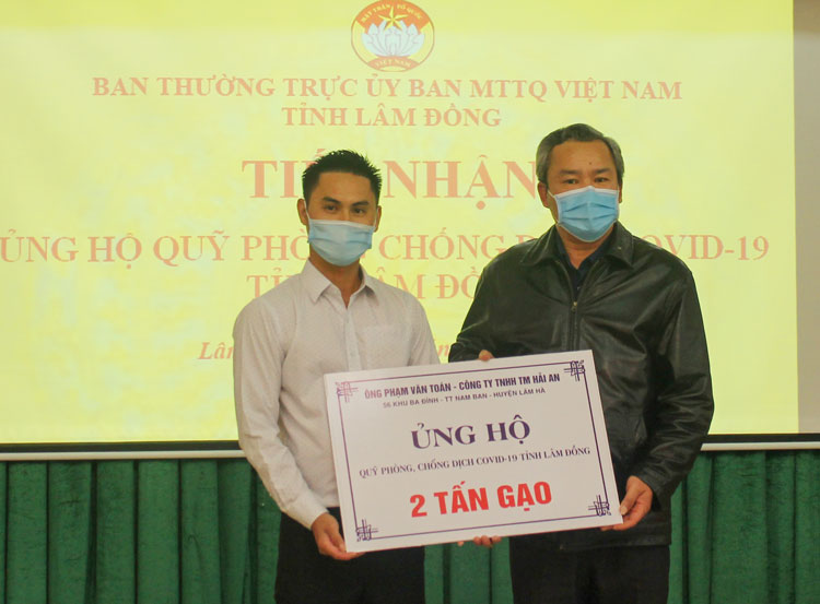 Ông Phạm Văn Toán - Giám đốc Công ty TNHH TM Hải An trao biểu trưng hỗ trợ 2 tấn gạo phục vụ phòng chống dịch Covid - 19 tỉnh Lâm Đồng