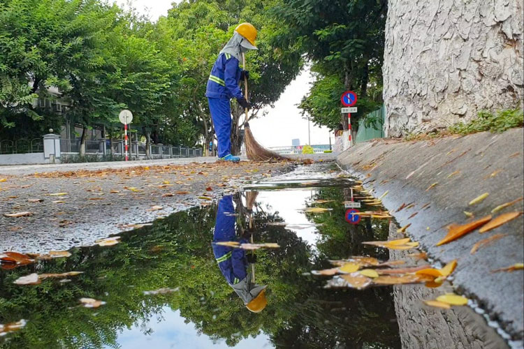 Người công nhân vệ sinh vẫn cần mẫn khoan thai quét rác làm sạch đường phố Đà Nẵng trong những ngày giãn cách xã hội
