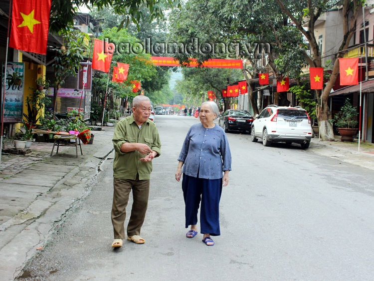 Bà Trần Thị Báu (bên phải) cùng hàng xóm trao đổi về con đường được đặt tên là Lâm Đồng. Ảnh: Lê Lâm