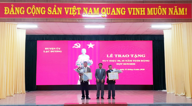 Đồng chí Ya Tiong - Phó Bí thư Thường trực Huyện ủy, Chủ tịch HĐND huyện Lạc Dương trao Huy hiệu 45 năm tuổi Đảng