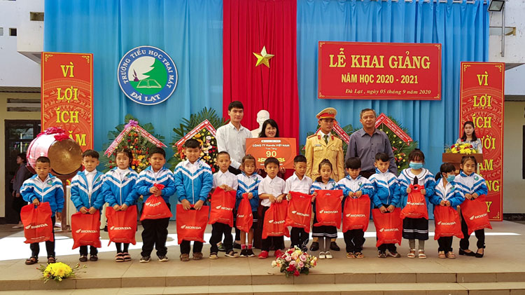 Đại diện cửa hàng Honda Ngọc Huệ, lãnh đạo Trường Tiểu học Trại Mát, UBND Phường 11 và Phòng CSGT thành phố Đà Lạt trao tặng MBH cho học sinh lớp 1