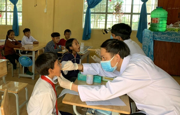 Cán bộ y tế khám sàng lọc bệnh bạch hầu cho học sinh Trường Tiểu học Đạ MRông, huyện Đam Rông