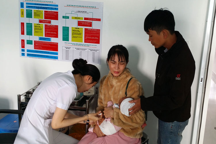 Người dân đưa con đến tiêm chủng tại Phòng Tiêm chủng vaccine Phúc An