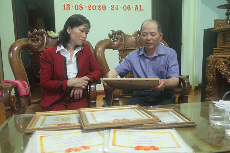 Vợ chồng ông Phan Hữu Anh và bà Nguyễn Thị Nga cùng những tấm bằng khen, giấy khen của 2 con trai