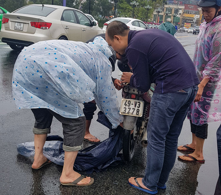 Một người dân đi xe máy bị áo mưa cuốn vào bánh xe sau té ngã tại cầu Ông Đạo chiều 17/10