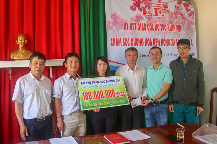 Anh Nguyễn Thế Hưng ký kết và bàn giao số tiền tài trợ chăm sóc đường hoa cho xã Tân Nghĩa