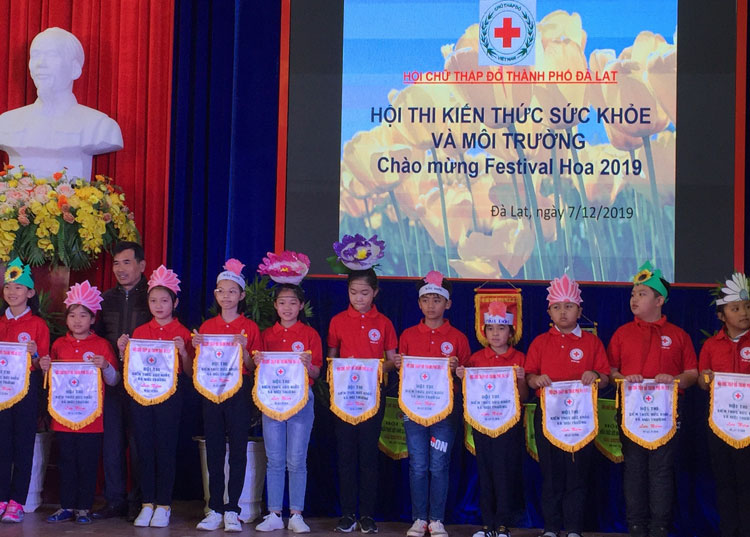 Chủ tịch Hội Chữ thập đỏ Đà Lạt trao cờ lưu niệm cho các đội tham dự hội thi kiến thức sức khỏe và môi trường