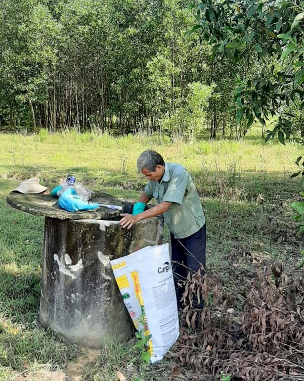 Một người dân Đạ Tẻh thu gom rác thải là bao bì hóa chất bảo vệ thực vật để đưa vào các bể thu gom trên đồng