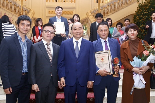 Thủ tướng Nguyễn Xuân Phúc với Phó Tổng giám đốc TTXVN Lê Quốc Minh và các tác giả đạt giải B (thể loại ảnh) thuộc Ban Biên tập Ảnh TTXVN tại lễ trao Giải Búa liềm vàng năm 2019