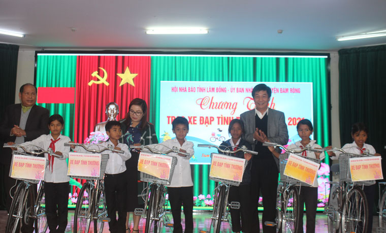 Ông Lê Văn Tòa cùng lãnh đạo huyện Đam Rông trao xe đạp cho các em học sinh